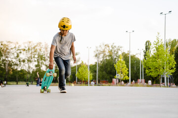Little boy wearing safety helmet skateboarding in park