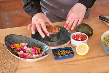 Chef preparing tartar at table in kitchen