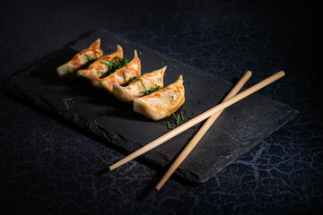 Serving board with fried dumplings and chopsticks