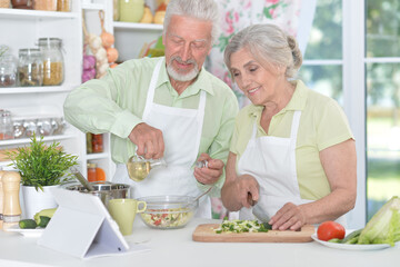 senior couple making salad together at kitchen