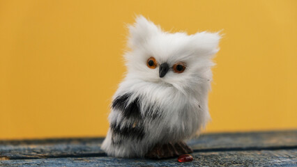 Buho de peluche sobre fondo amarillo