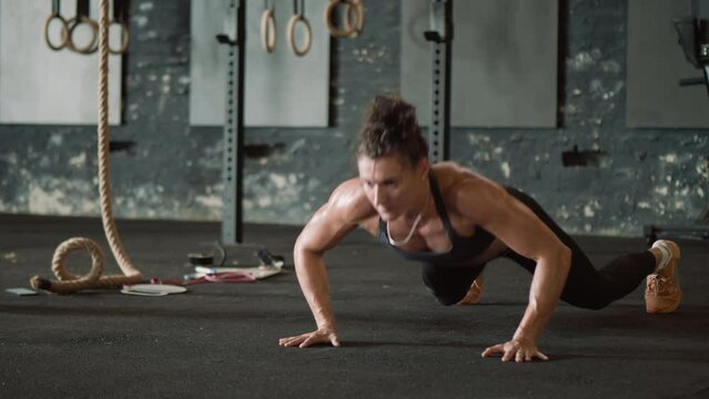 Woman doing jumping push up in the gym