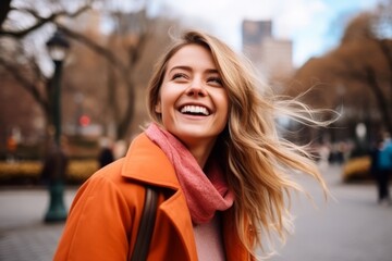 Portrait of a happy young woman in an orange coat and scarf