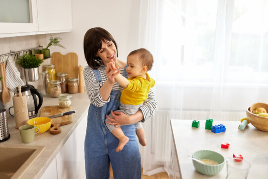 Mother dancing with her baby boy in the kitchen - Powered by Adobe