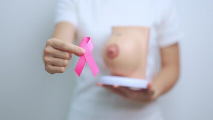 Pink October Breast Cancer Awareness month, doctor woman with pink Ribbon and Breast Anatomy model. National cancer survivors month, health diagnosis, Mother and World cancer day concept