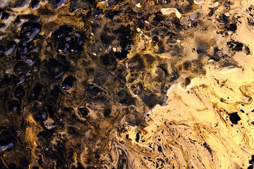 Exclusive beautiful pattern, abstract fluid art background. Flow of blending golden black paints mixing together. Blots and streaks of ink texture for print and design