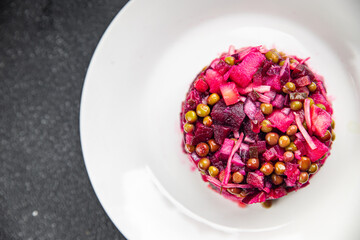 beet salad vegetables peas, carrots, potatoes, onions, pickled cucumber appetizer meal food snack on the table copy space food background rustic top view keto or paleo diet vegetarian vegan food