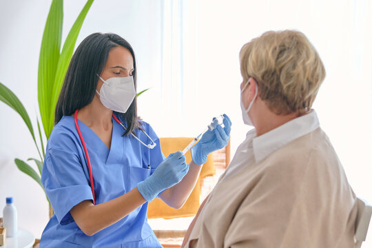 Physician filling syringe with vaccine against anonymous patient