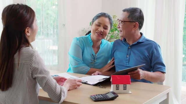 Real estate agent young asian businesswoman giving document to senior couple signing on document about buying home or insurance residential and handshake, estate and signature, business and insurance.