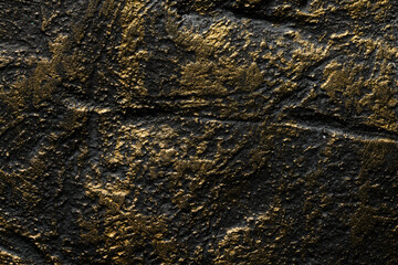 Decorative black gold putty background. Wall texture with filler paste applied with spatula,...