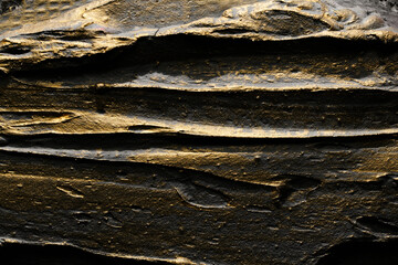 Decorative black gold putty background. Wall texture with filler paste applied with spatula,...