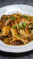 Delicious Batik Clam Served with Sauce on a White Plate 