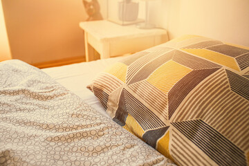 View of the bed in the morning.Detail of pillow and blanket.