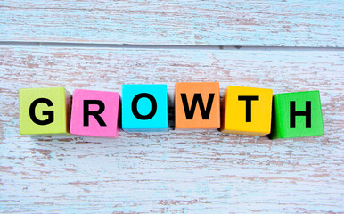 The word Growth on wooden cubes on a blue table