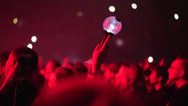 Bts k pop band fan raise hand up hold bomb light stick lamp. Fun korean people enjoy kpop live music concert. Crowd hang out cool night show. Asian idols army wave red flash light. Joy party fest tour