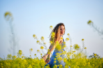 Naklejka na ściany i meble Carefree woman standing on verdant meadow in countryside