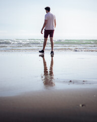 A man walks calmy along the sea
