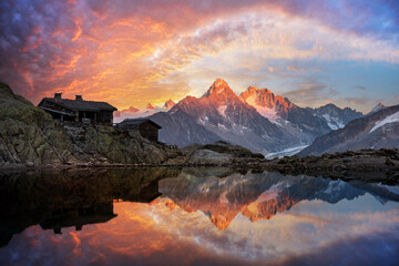 Wooden cabin on Lac Blanc lake in French Alps during incredible sunset. Monte Bianco mountains...
