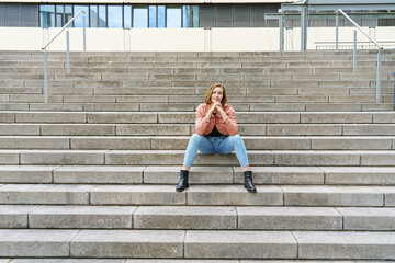 Young woman sitting on stairs in the city