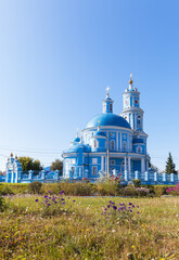 View of old beautiful blue Orthodox Church of 1816 in honor of Kazan Icon of Mother of God in classicist style in village of Telma on sunny day. Сhurch has children's Sunday school