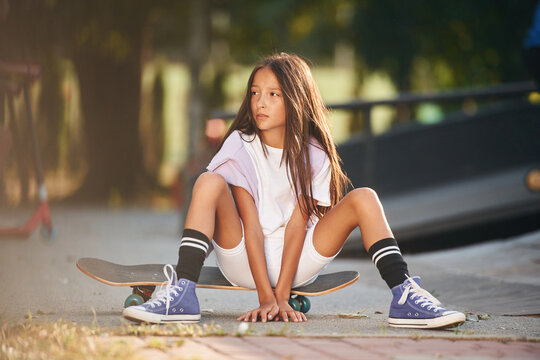 In the extreme sports park. Happy little girl with skateboard outdoors © standret