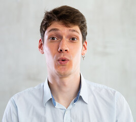 Fototapeta premium Portrait of young surprised guy in studio