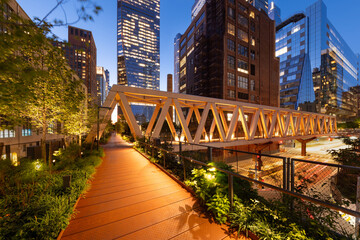 High Line Park timber wooden truss bridge in evening with Hudson Yards skyscrapers. This new section opened in 2023. Chelsea, Manhattan, New York City - 649272763