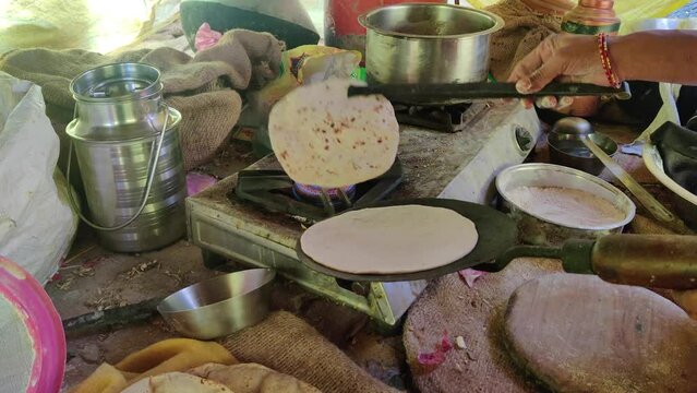 Making fresh chapatis on a gas stove using a tong
