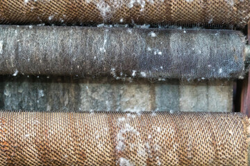 Details of a wool carding machine as a structural background.