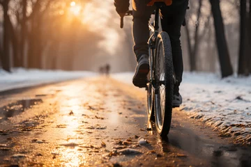 Selbstklebende Fototapeten close up man riding a bicycle on a road in a winter snow © AspctStyle