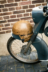 old leather helmet from the seventies on an old gray moped