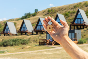 Man holds the keys to a new quart or house. The keys open and close the door lock. The owner opens...