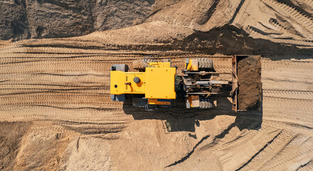 Yellow Industrial excavator working on sand quarry. Aerial top view open pit mine industry concept