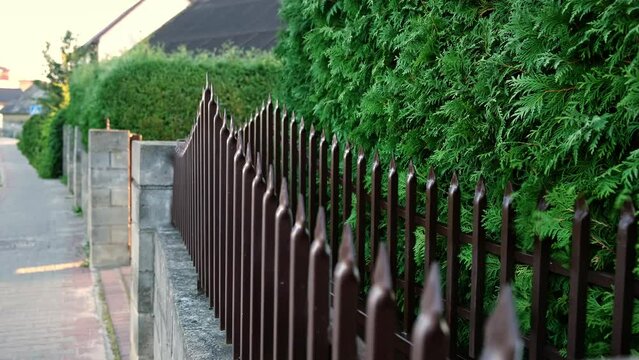 Closing of automatic entrance gate of brown color made of metal. Block fence. Entrance group for cars in the private house. Distance control. Smart home system. Close-up.