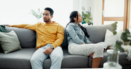 Unhappy, fight and couple angry on a couch together duo to infertility, argument and toxic relationship in a home. Conflict, divorce and man has problem with woman in a living room sofa for cheating