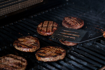 BBQ burgers prepared on barbecue fire flame grill with beef meat