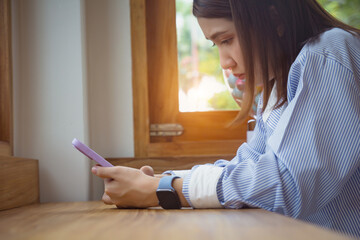 Businesswoman with hand using smart phone at coffee shop.