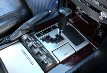 Close up of automatic transmission gear lever in modern SUV. Control panel for off-road functions. 4WD switch. SUV driving mode switch. The automatic gear lever shows the gear shift position in a car.