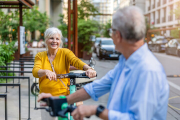 Senior couple riding electric scooters in the city
