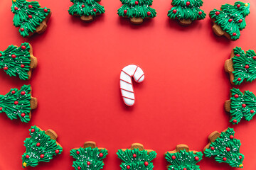 Christmas tree shaped gingerbread cookies covered with icing, flat lay.