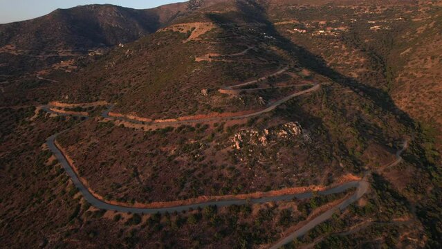 4K aerial drone shot of valley in west Crete at red sunset, with winding scenic road
