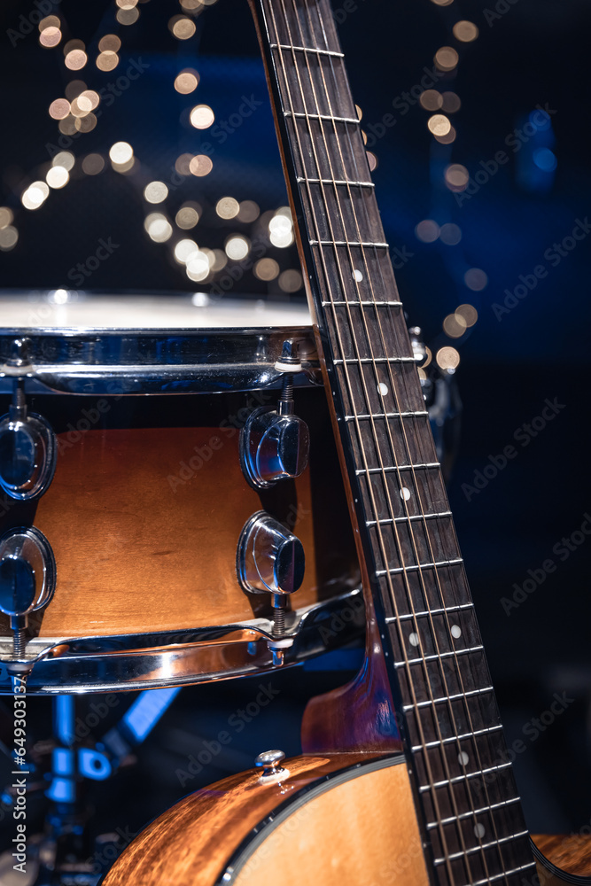 Wall mural snare drum and guitar on a blurry dark background with bokeh.