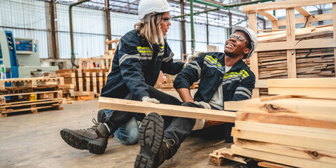 Warehouse worker man person has work related accident falls while trying to pick up wooden panel from the Shelf. colleagues call for help and medical assistance, injury and heal accident insurance