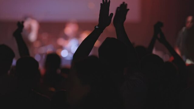 People enjoy a concert at the nightclub - people clapping their hands with a beat