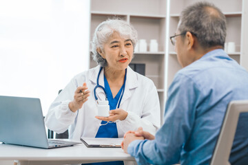 Elderly patient asian people attentively listening to mature doctor, receiving valuable health advice and discussing comprehensive health results in caring medical environment. Health Consultation