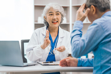 Elderly patient asian people attentively listening to mature doctor, receiving valuable health advice and discussing comprehensive health results in caring medical environment. Health Consultation