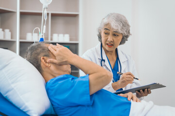 Senior elderly male patient and asian people mature woman doctor, showcasing importance of healthcare expertise and patient support. caring senior doctor assisting elderly patient in hospital bed