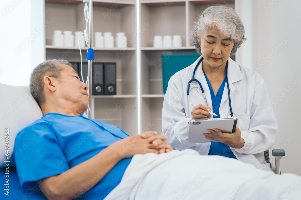 Wall mural Senior elderly male patient and asian people mature woman doctor, showcasing importance of healthcare expertise and patient support. caring senior doctor assisting elderly patient in hospital bed