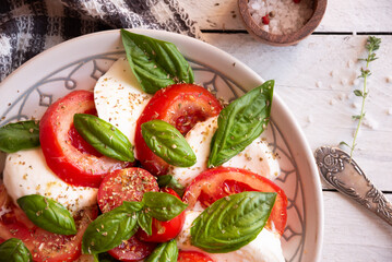 Caprese salad with mozzarella cheese and tomatoes of Italian cuisine
