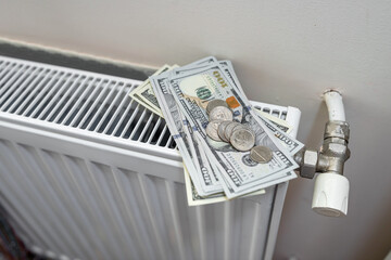 Radiator with dollar banknotes and coin cent as  expensive heating cost